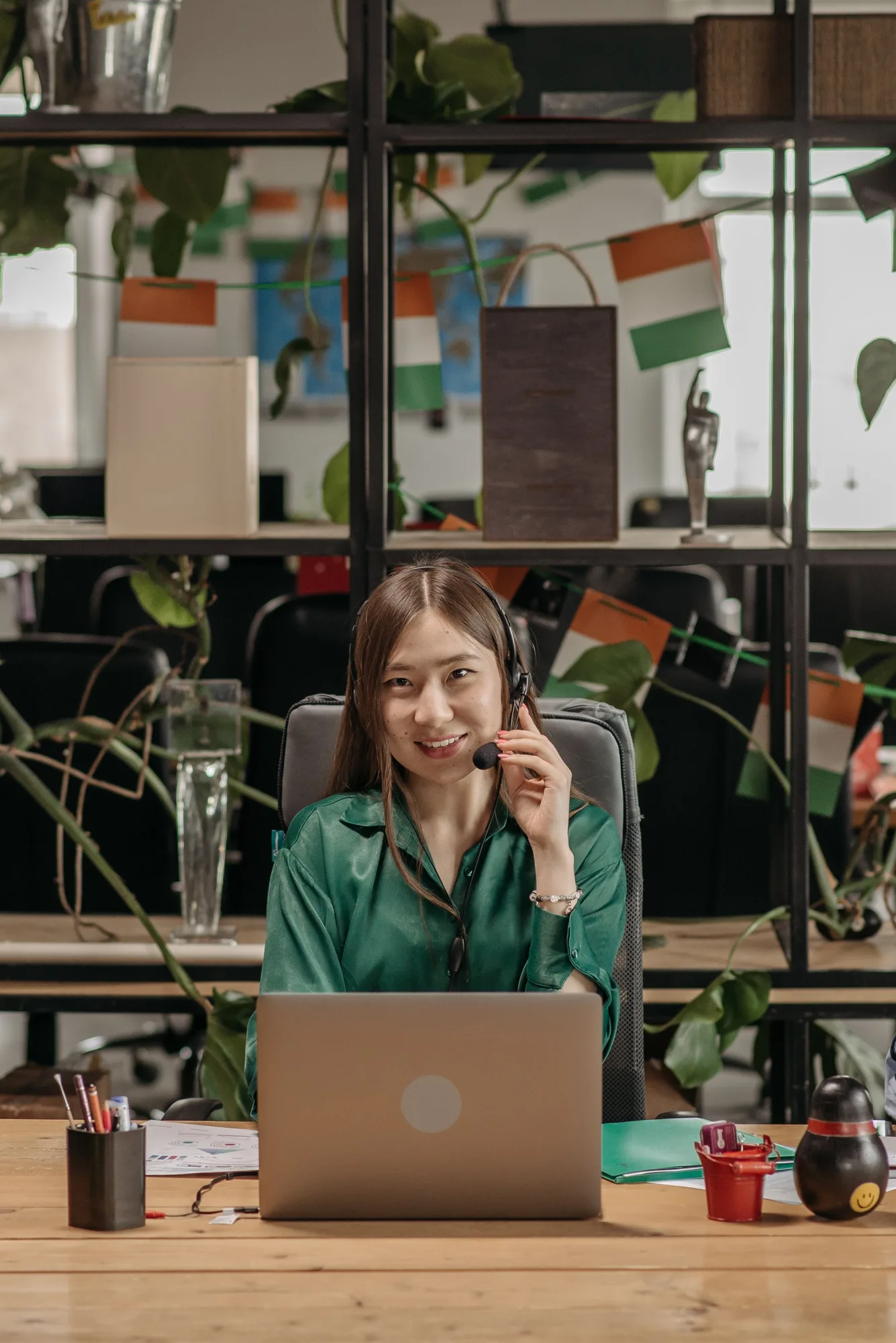 Woman wearing a headset smiling at a laptop