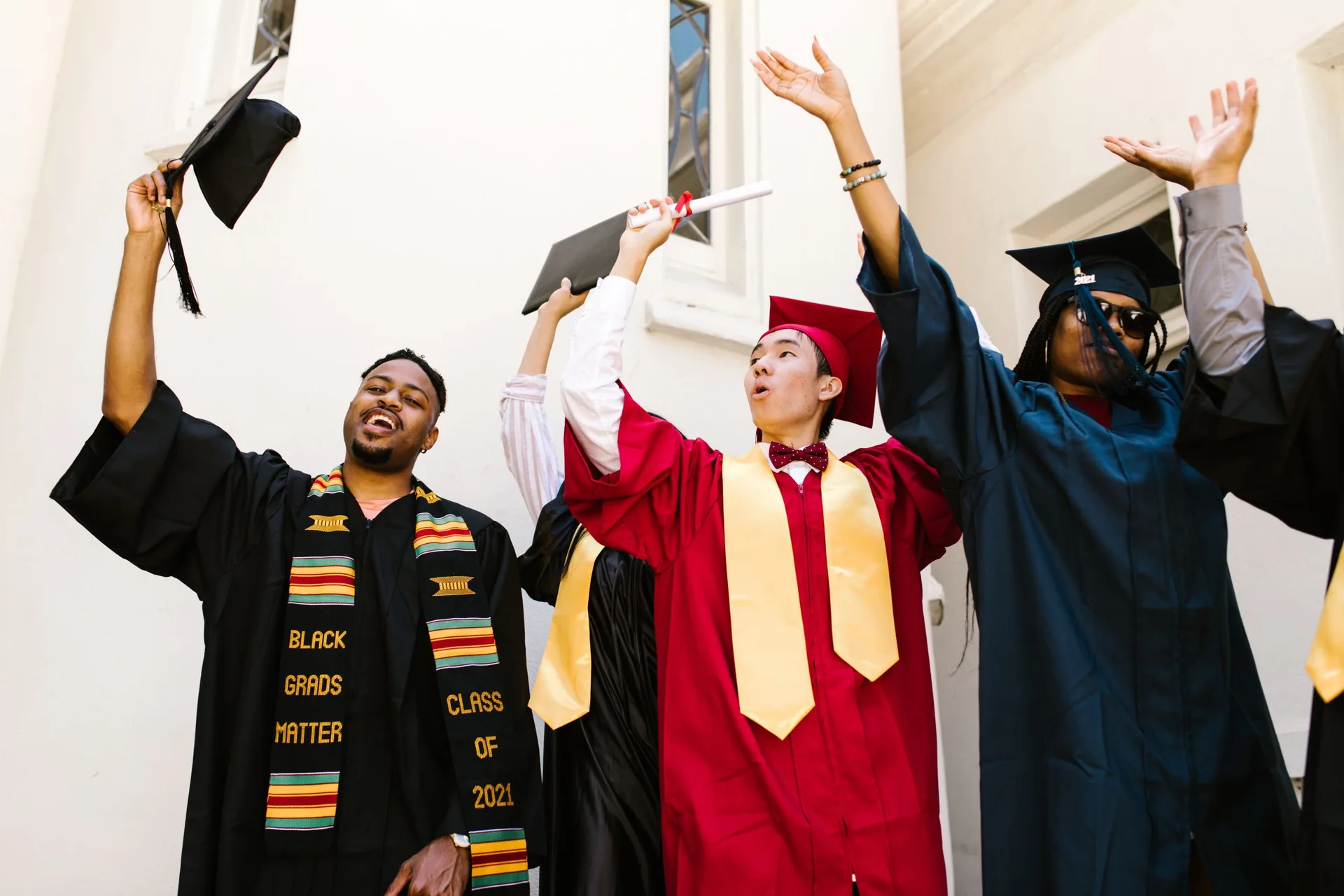 Graduates in gowns throwing their caps in the air