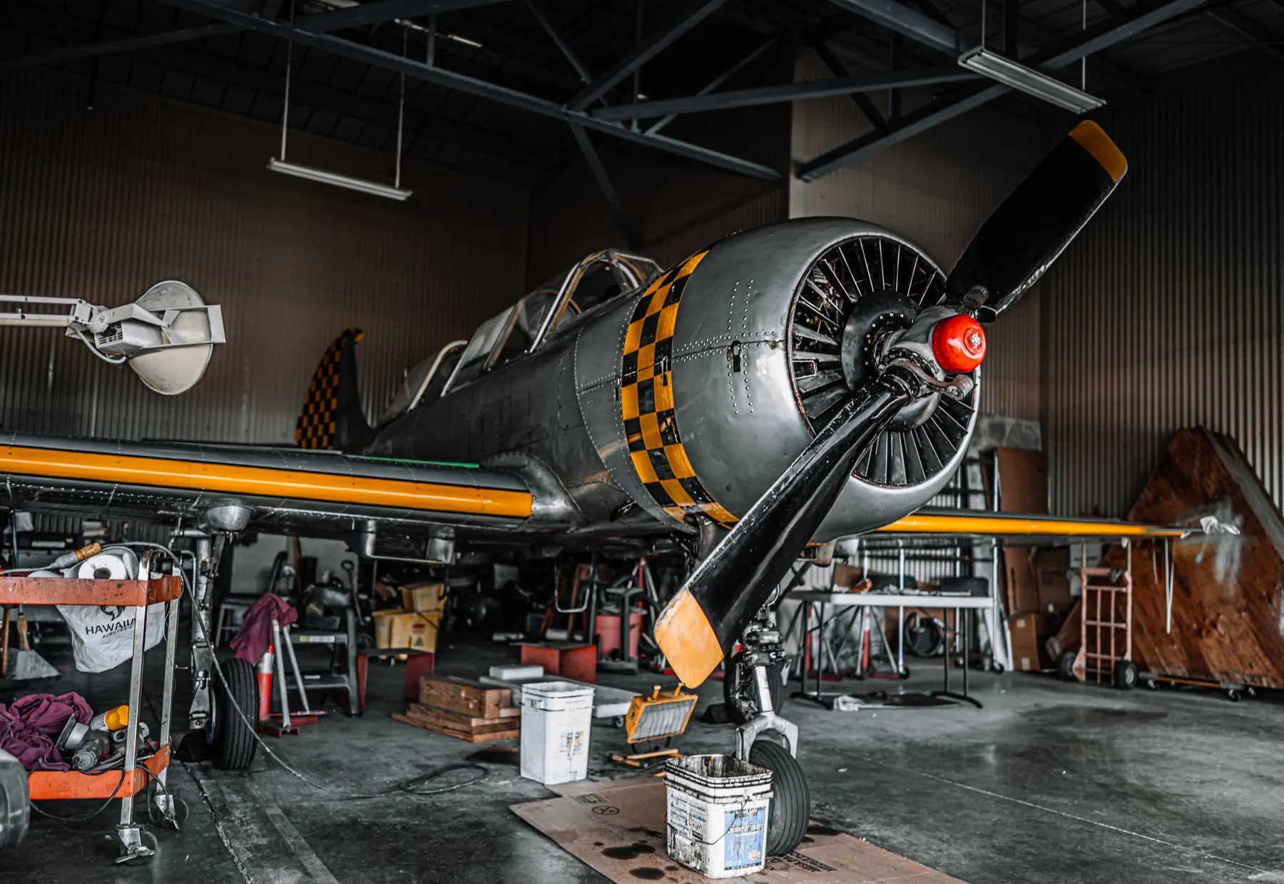 Vintage propeller aircraft under maintenance in a hangar