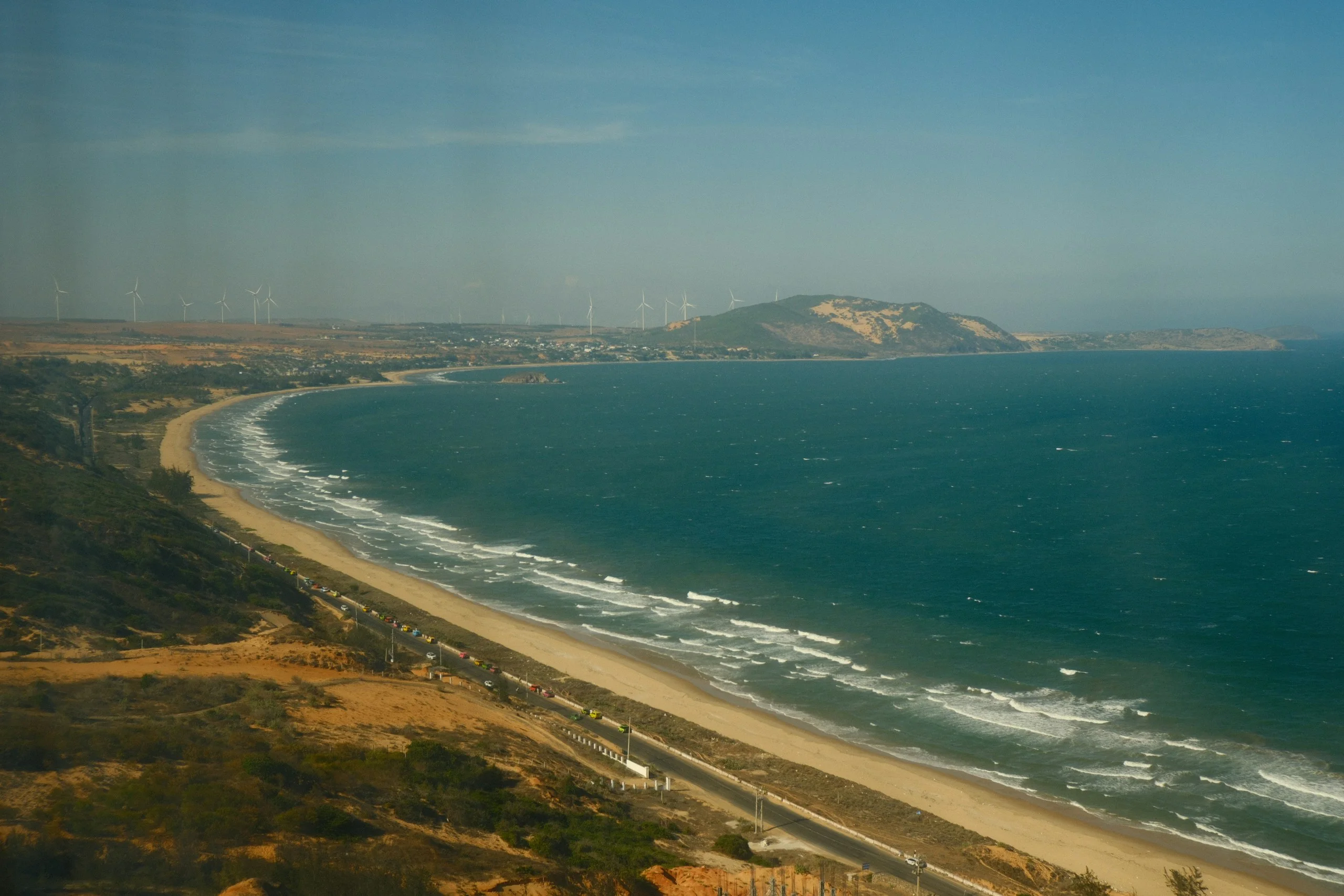Aerial view of a curving sandy beach meeting the ocean