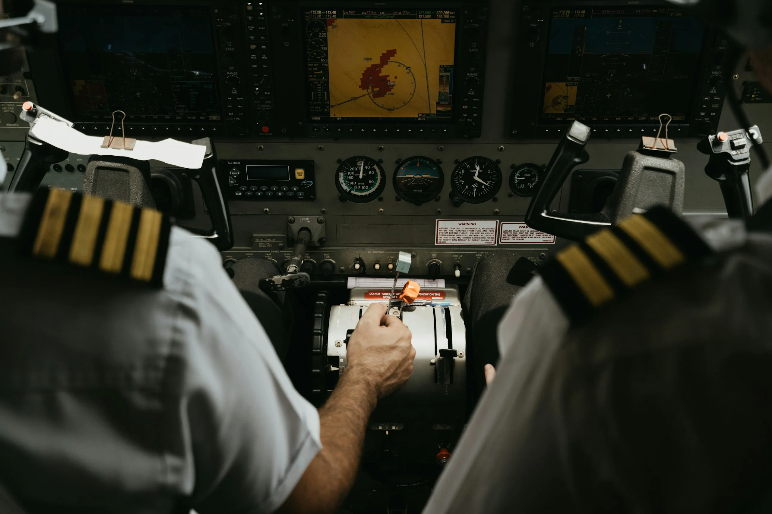 Two pilots in uniform in a training aircraft cockpit